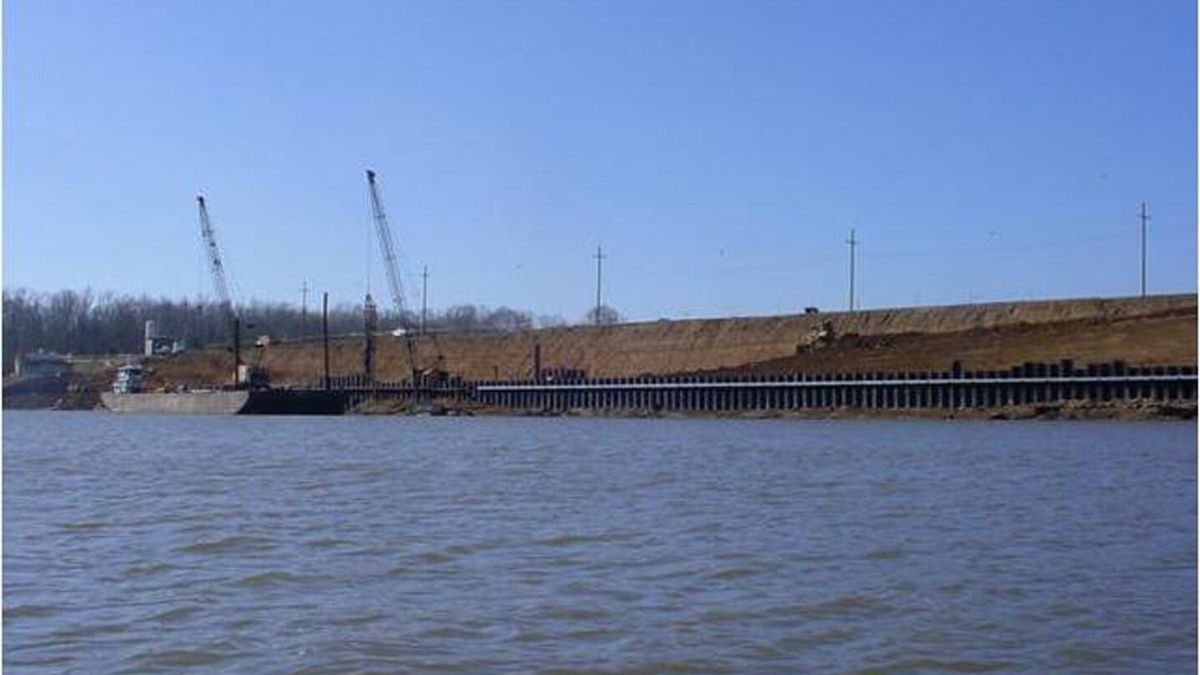 Barges and equipment working along a levee during a waterfront stabilization project